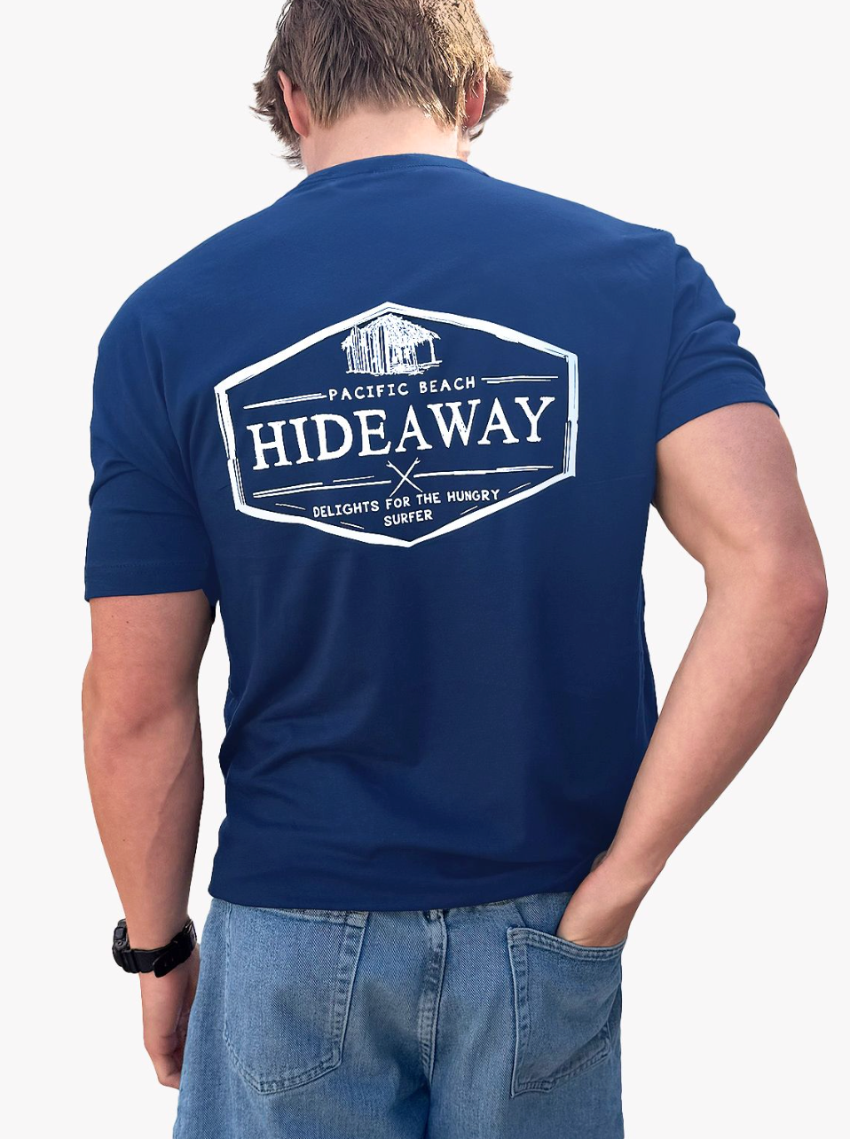 Person wearing a blue t-shirt with 'Hideaway' logo on the back, standing against a white background