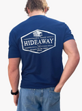 Person wearing a blue t-shirt with 'Hideaway' logo on the back, standing against a white background